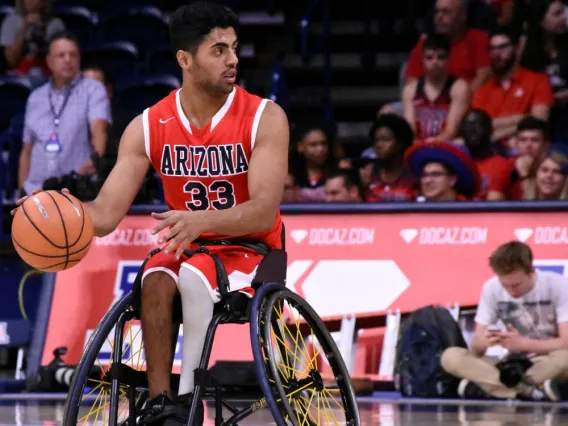 men's basketball player dribbling the basketball