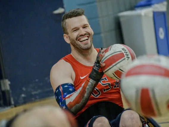 Photo of Paralympian Josh Wheeler smiling and holding a Rugby ball 