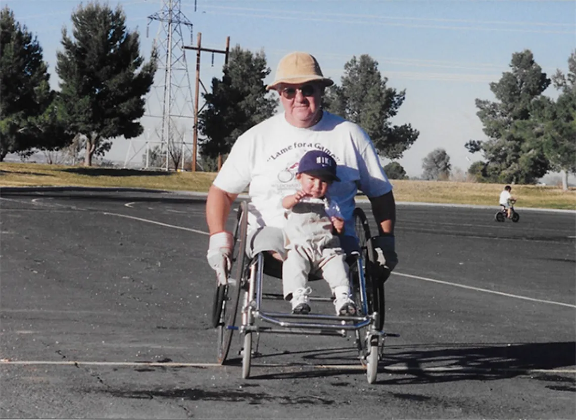 Founder of the University of Arizona's wheelchair basketball program, Rudy Gallego, and his son pose for a picture.