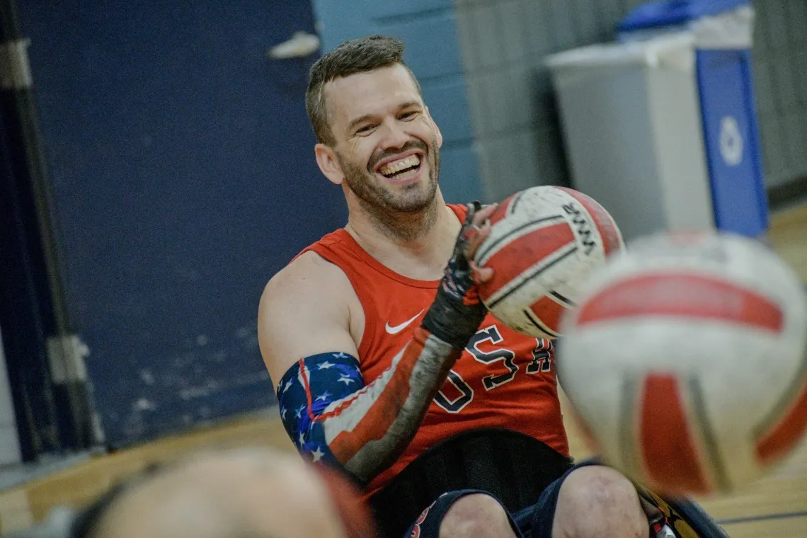 Photo of Paralympian Josh Wheeler smiling and holding a Rugby ball 